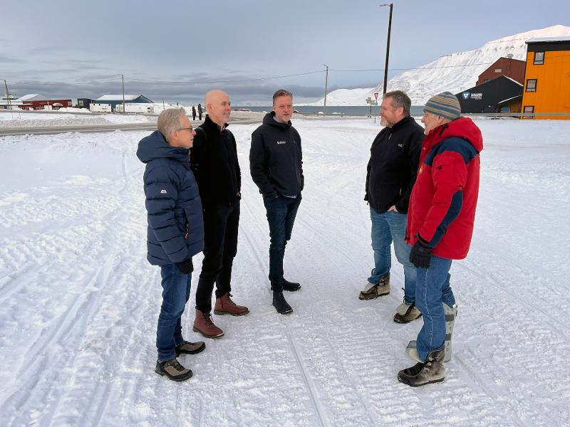 People standing in a semi-circle in a snowy street.